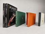 three books are lined up in a row on a white surface