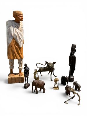 une statue représentant un homme debout à côté d'un groupe d'animaux