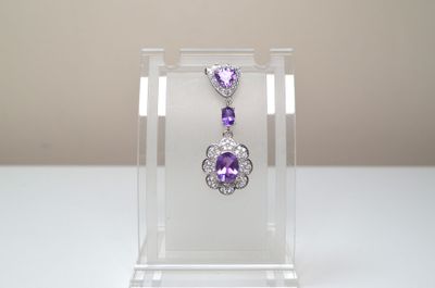 boucles d'oreilles en cristal et en améthore dans un présentoir en acrylique