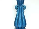 a blue vase that is sitting on a table