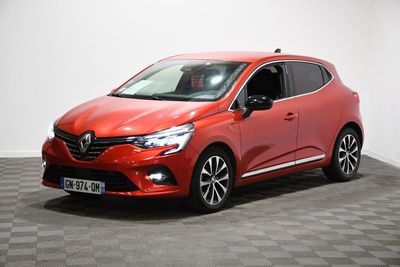 une voiture rouge est garée dans une pièce au sol en damier