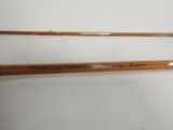 a pair of wooden fishing rods sitting on top of a white surface