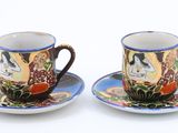 two cups and saucers sitting on a saucer