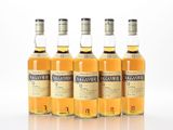 four bottles of whisky are lined up on a white surface