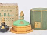 un petit flacon de parfum à côté d'une petite boîte de parfum