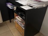 un bureau noir avec un tiroir rempli de dossiers