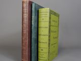 trois livres sont empilés sur une table