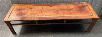 une vieille table en bois avec un tiroir en dessous, posée sur un sol carrelé
