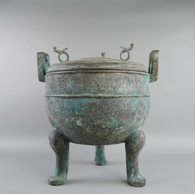 une image représentant un grand pot en bronze posé sur un socle
