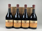quatre bouteilles de vin dans un coffret en bois posé sur une table