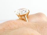 a person ' s hand holding a ring with a diamond on it