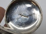 a close up of a silver pocket watch in a person ' s hand