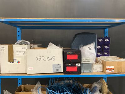 une étagère sur laquelle se trouvent des boîtes et des fils, dans une pièce