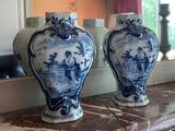 two blue and white vases sitting on a mantle