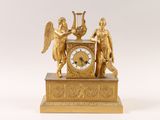 a gold clock with angels and harps on it