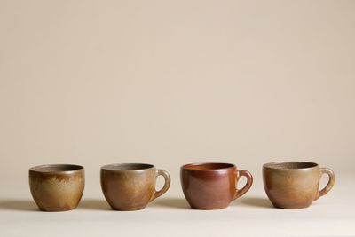 quatre tasses à café sont alignées sur une table