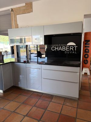 a kitchen that has a television on the wall in it