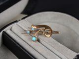 a gold ring with a turquoise stone in it