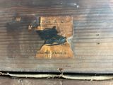 a close up of a piece of wood with a metal tag on it