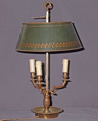 une lampe posée sur une table, avec un abat-jour vert