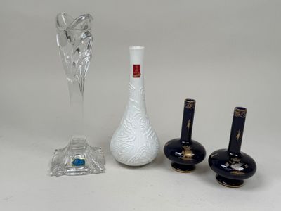 three vases, a glass vase, and a candle holder on a table
