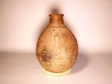 a brown vase sitting on a white surface