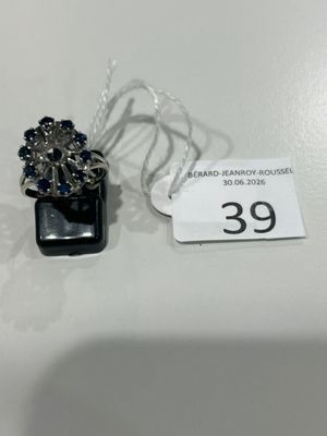 une bague ornée de pierres bleues et une étiquette de prix posée sur une table