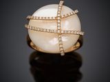 une bague en perles blanches et diamants sur une surface noire