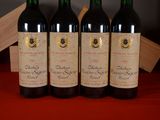 three bottles of red wine are lined up on a red table