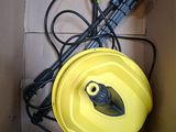 a yellow hose in a box with a black cord