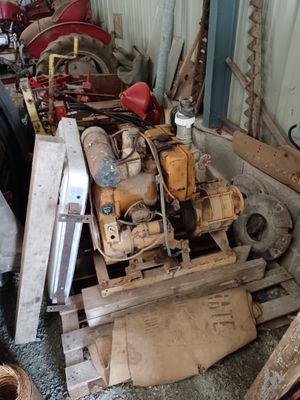 a pile of old machinery in a garage next to a pile of wood