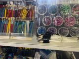 many pens and pencils on a shelf in a craft shop