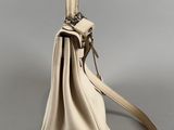 side view of a handbag with a strap and a shoulder strap