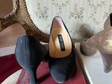 two pairs of shoes sitting on a box next to a chair