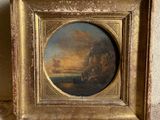 une vieille photo représentant un tableau représentant un coucher de soleil, dans un cadre doré