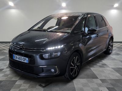 La Citroën grise est garée sur un sol à damier dans un garage.