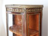 a wooden cabinet with a glass door and a shelf