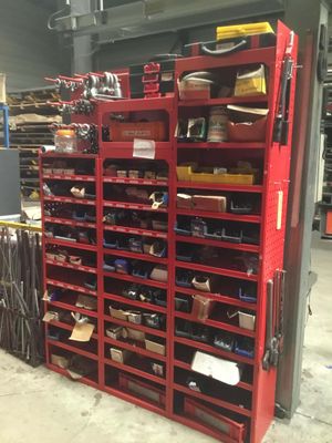 a red shelving filled with lots of tools in a warehouse