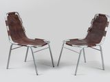 deux fauteuils en cuir marron avec des pieds en métal, sur fond blanc