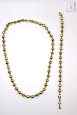 a gold beaded necklace with a cross on it