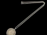 une image représentant un collier en argent avec une pièce suspendue à une chaîne