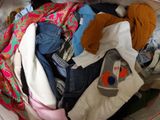 a bag full of clothes that is sitting on a bed