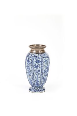 un vase bleu et blanc posé sur une table blanche