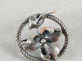silver ring with a flower and leaves on it on a white surface