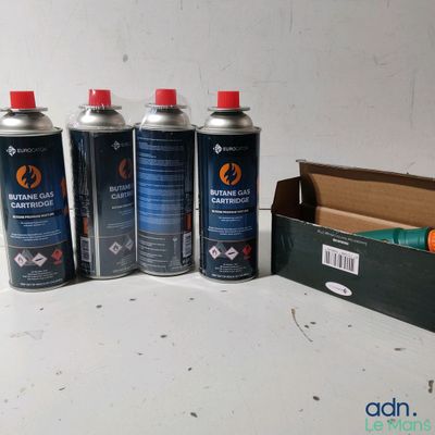 four canisters of paint sitting on a table next to a cardboard box