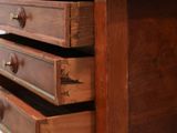a wooden desk with three drawers and a keyboard on top of it