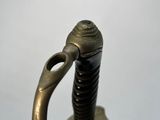 a close up of a sword with a metal handle on a stand