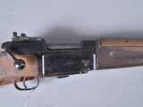 an old rifle with a wooden handle on a white surface