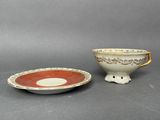 two cups and saucers, one red and the other white