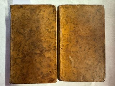 deux vieux livres posés sur une table l'un à côté de l'autre